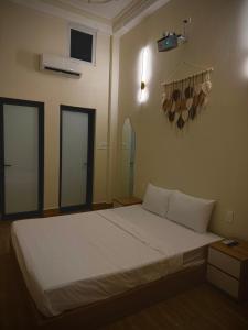 un letto in una stanza con due finestre di Ngo Homestay a Hue 1 altra foto