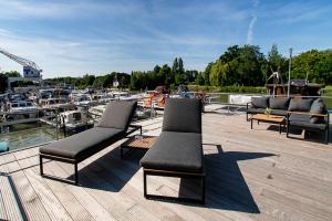 a group of chairs sitting on a dock with boats at ANKERLOFT - Hausboot in Hannover