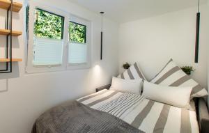 a bedroom with a bed and two windows at ANKERLOFT - Hausboot in Hannover