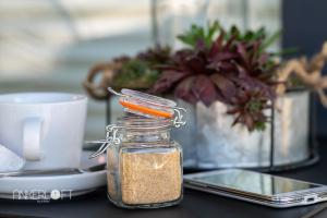 a jar of seasoning sitting on a table with a coffee cup at ANKERLOFT - Hausboot in Hannover