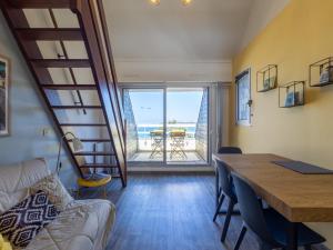 a living room with a dining room table and a view of the ocean at Ty Fox by Madame est Servie in Perros-Guirec +12 photos