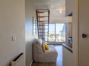 a living room with a white couch and a ladder at Ty Fox by Madame est Servie in Perros-Guirec