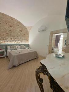 a bedroom with two beds and a brick wall at ALLE TERRAZZE di Castellana Grotte in Castellana Grotte