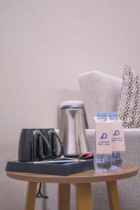 una mesa con cafetera y una botella de agua en Daif Inn Serviced Apartments - Al Naseem, en Riad