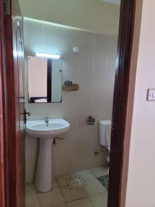Un baño con lavabo, espejo e inodoro. en 2 Bedroom in Nairobi, en Nairobi