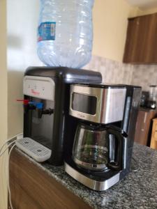 Una cafetera en un mostrador con una botella de agua. en 2 Bedroom in Nairobi, en Nairobi