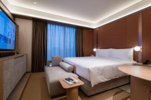 A bed or beds in a room at Shanghai Changfeng Business District Orange Crystal Hotel