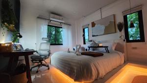 Un dormitorio con una cama, un escritorio y ventanas. en Modern Zen Houses Soft mattress 900 Mbps 10min beach, en Ko Pha Ngan