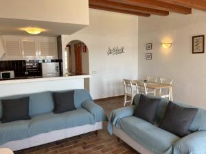 sala de estar con 2 sofás azules y cocina en Es CASTELL 2 7 by SOM Menorca, en Fornells 11 fotos más