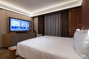 A bed or beds in a room at Shanghai Changfeng Business District Orange Crystal Hotel