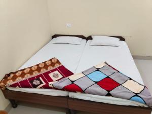 a bed with two pillows on it in a room at Krishna Bhavan And Events in Nāgaur