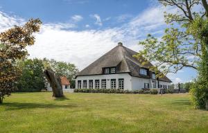 un gran edificio blanco con techo de paja en T-4 Hoeve Holland, en De Cocksdorp