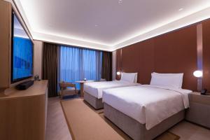 A bed or beds in a room at Shanghai Changfeng Business District Orange Crystal Hotel
