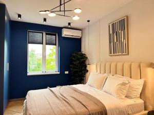 a bedroom with a bed with a blue wall at Old Town Luxe Loft in Iaşi