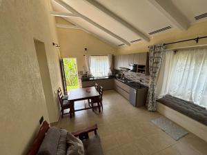 a living room with a table and a kitchen at Faraja House in Maragoli
