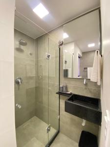 a bathroom with a glass shower and a sink at Wanderlust Hostel in Maceió +53 photos