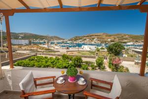 a table and chairs on a balcony with a view of a harbor at Stefanos Studios in Skala