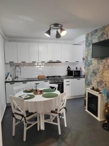a kitchen with a white table and chairs in it at Modern Central Apartament in Câmpulung Moldovenesc