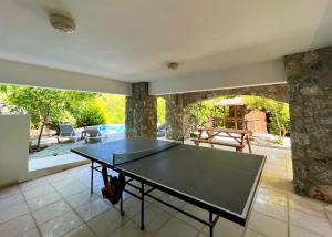 a ping pong table in the middle of a room at Luxurious Villa Beckham by HolidayKeys in Kérynia