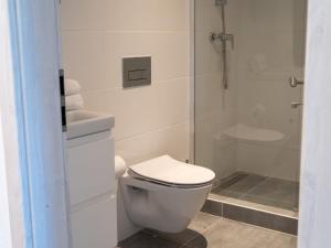 a white bathroom with a toilet and a shower at Apartment Wohnung Garten 1 Seeblick by Interhome in Strobl +27 photos