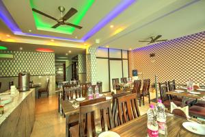 un ristorante con tavoli e sedie in legno e luci di Hotel Smart Lax a Nuova Delhi Altre 14 foto