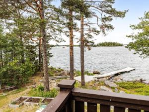 a wooden bench next to a body of water at Holiday Home Huset på Udden by Interhome in Söderhamn