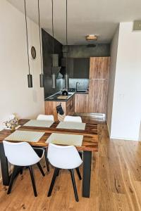 扬斯凯拉兹涅Apartment Ski&Bike Siréna-5 by Interhome的配有木桌和白色椅子的餐厅
