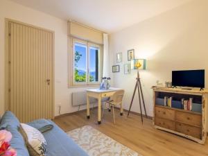 sala de estar con sofá azul, mesa y TV en Apartment Il Gianlupo Azzurro by Interhome, en Belgirate