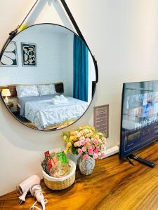 a mirror on a table with a bed in a bedroom at 405MSNK Maison Luxe Twin Studio l Balcony & Kitchen in Can Tho