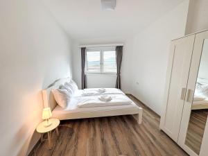 a white bedroom with a bed and a window at Apartment Mentenwirt Alp Lungau by Interhome in Sankt Michael im Lungau