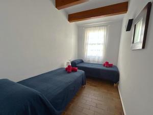 Dos camas en una habitación con rojo. en ES CASTELL 2 3 by SOM Menorca, en Fornells