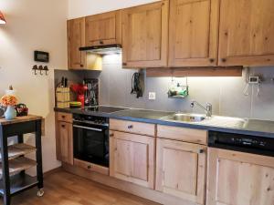 a kitchen with wooden cabinets and a sink at Apartment Mon Abri by Interhome in Les Diablerets