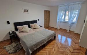 a bedroom with a large bed and a wooden floor at Villa Aristea Crikvenica by Villas Guide in Škrljevo