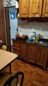 a kitchen counter with wooden cabinets and a table with chairs at Arcoiris in General Acha