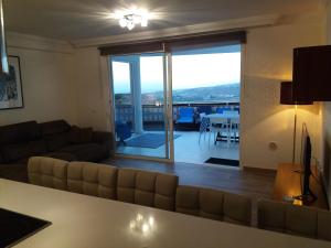 a living room with a couch and a living room with a view at Apartment 3 Bedrooms Heated Pool in Adeje