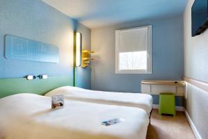 Un pat sau paturi într-o cameră la Ibis Budget Cergy St Christophe +70 fotografii