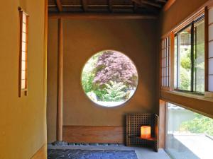 ein Zimmer mit einem runden Fenster an der Wand in der Unterkunft Momoyama in Matsumoto