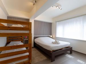 Un dormitorio con dos literas y una ventana. en Apartment Arcona by Interhome, en Bredene
