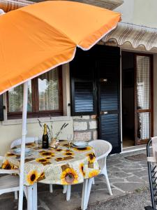 a table with an orange umbrella on a patio at Del Casel Apartment in San Zeno di Montagna