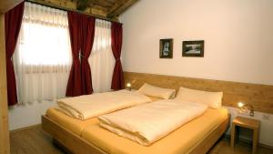 a bedroom with a large bed with a window at Skihütte Silberleiten, 8 Personen in Krimml