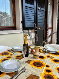 a table with plates and a bottle of wine at Del Casel Apartment in San Zeno di Montagna