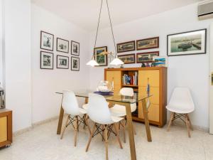 a dining room with a glass table and white chairs at Apartment Mar d'Aro by Interhome in Platja  d'Aro