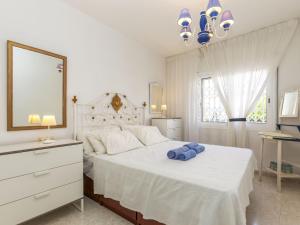 a white bedroom with a large bed with blue towels on it at Apartment Mar d'Aro by Interhome in Platja  d'Aro