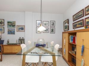 a dining room with a glass table and white chairs at Apartment Mar d'Aro by Interhome in Platja  d'Aro