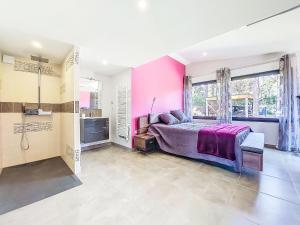 Schlafzimmer mit rosa Wänden, einem Bett und einer Dusche in der Unterkunft Villa Villa les Verdiers by Interhome in Biscarrosse