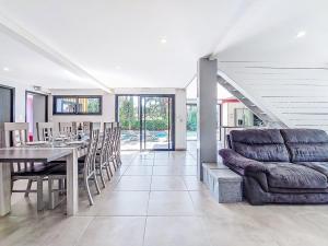 ein Esszimmer mit Tisch und Couch in der Unterkunft Villa Villa les Verdiers by Interhome in Biscarrosse