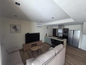 a living room with a white couch and a kitchen at Janeixa 02 in Lariño