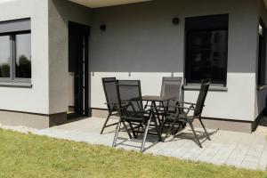 un groupe de chaises et une table sur une terrasse dans l'établissement Apartament Komfort, à Uniejów