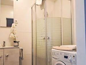 Un baño con lavadora en la ducha. en Apartment Wohnung 413 Bergblick by Interhome, en Strobl