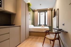 a bedroom with a bed and a desk and a chair at Ola Living Chamartín Studios in Madrid